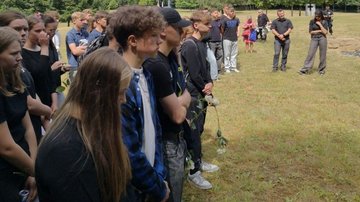 Besucher sowie die zahlreichen Schüler bei der Einsegnung am Grab.